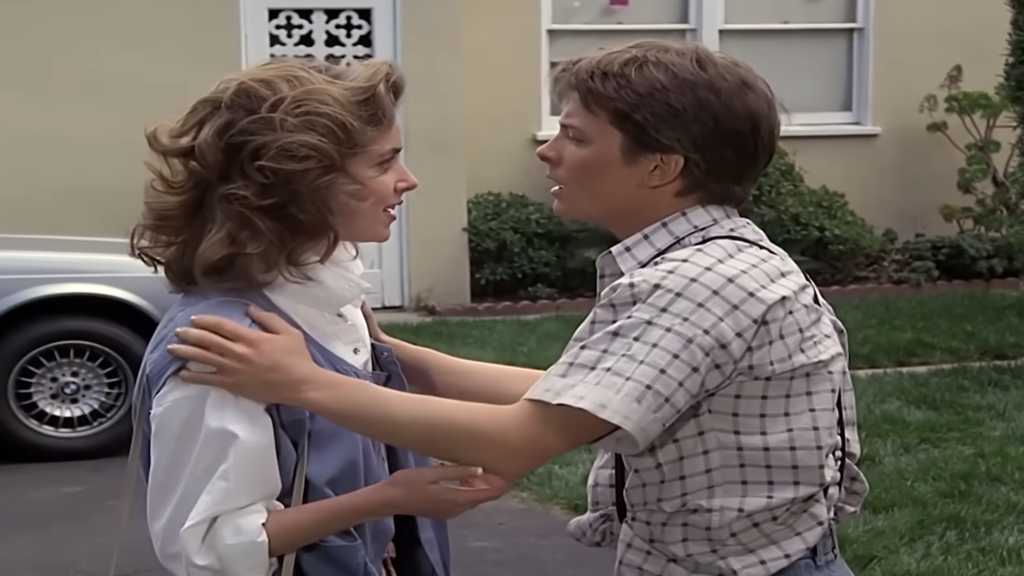 Actor Claudia Wells as Jennifer Parker smiling next to Marty McFly in Back to the Future.