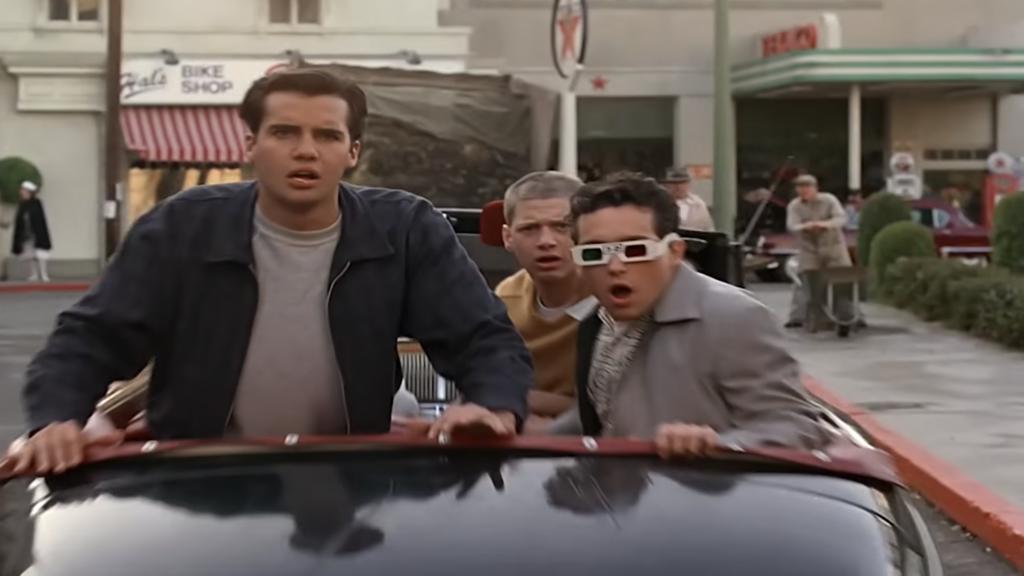 Michael J. Fox as Marty McFly standing next to the DeLorean time machine in Back to the Future.